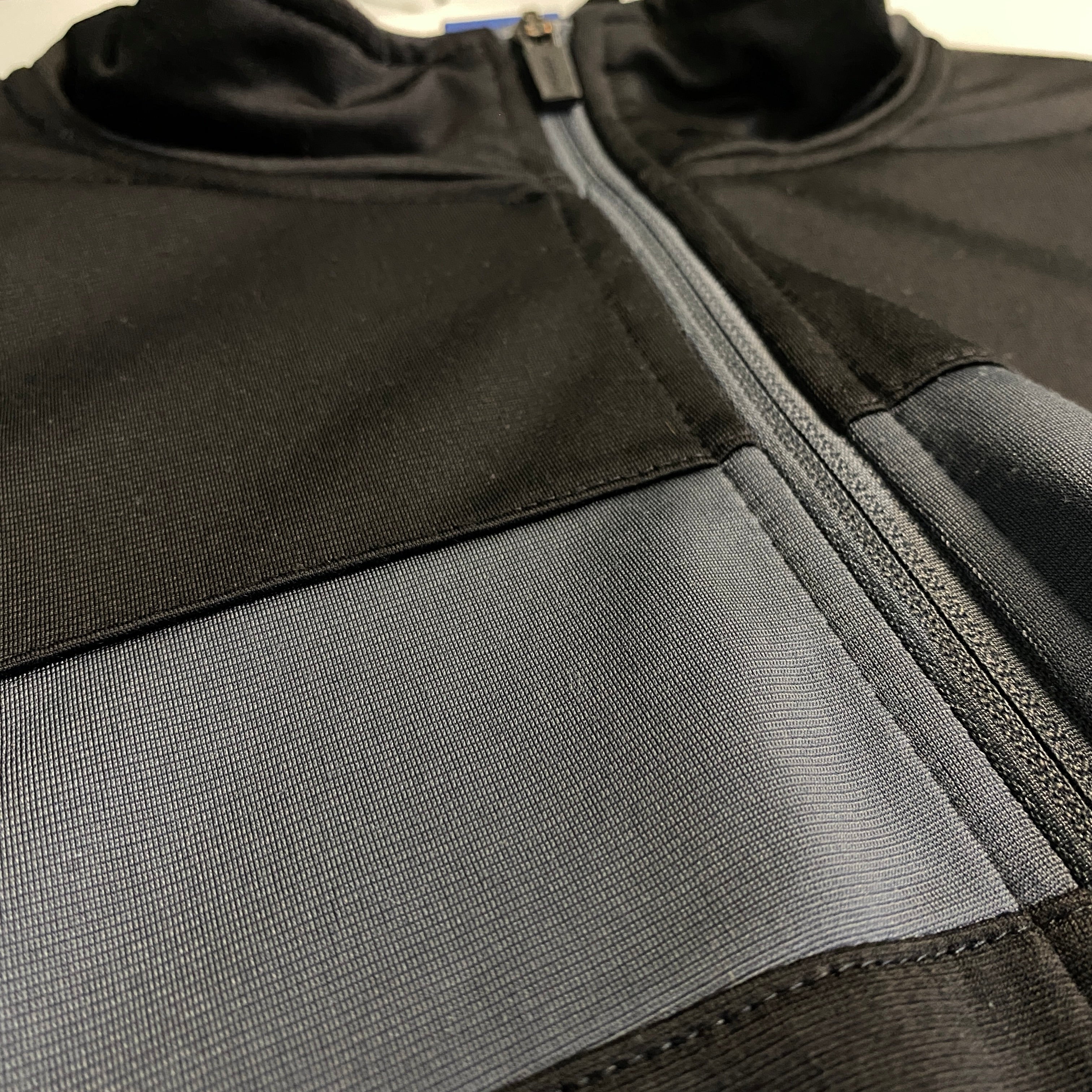 CHAQUETA REEBOK NEGRA CON PANEL AZUL Y GRIS