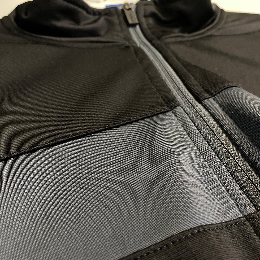 CHAQUETA REEBOK NEGRA CON PANEL AZUL Y GRIS