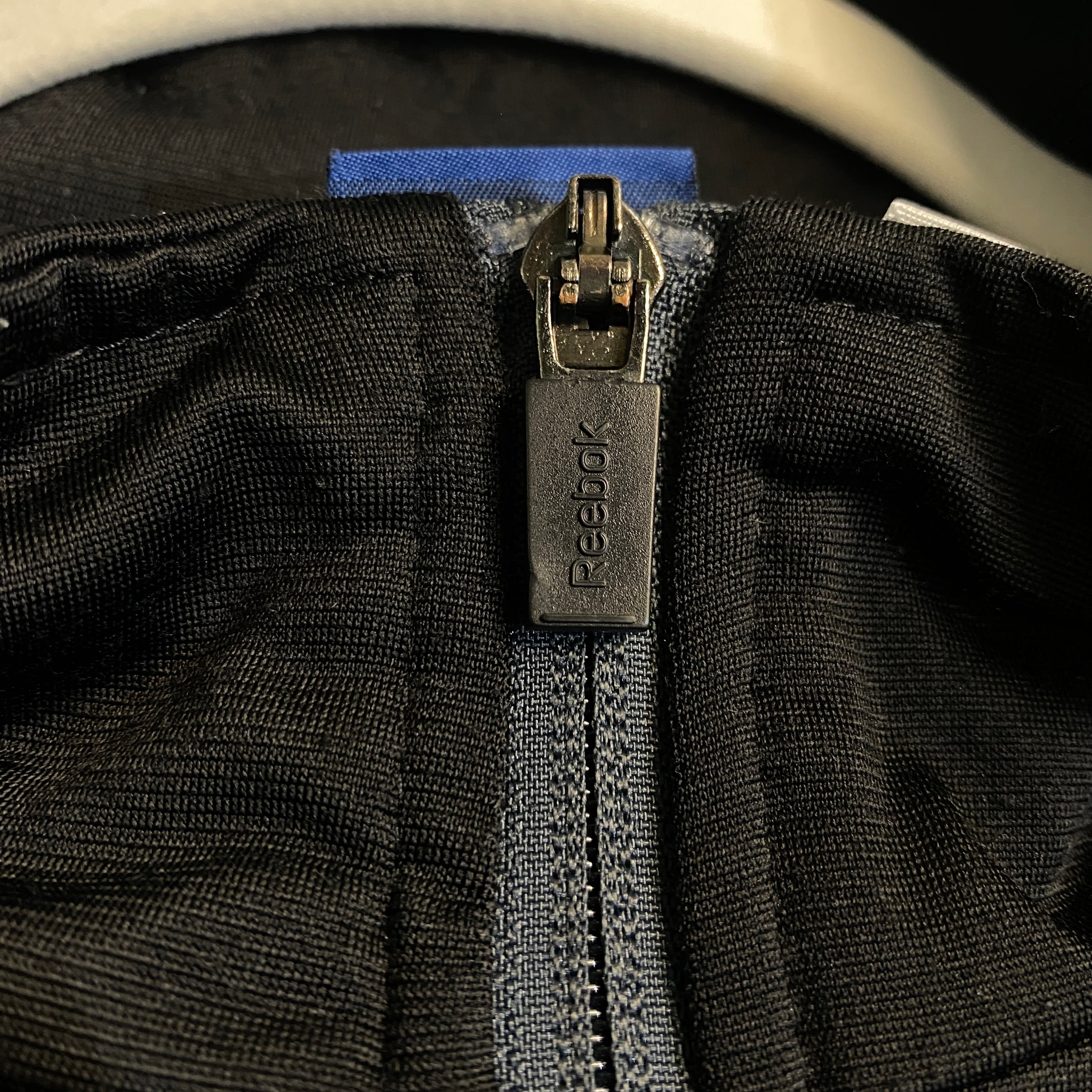 CHAQUETA REEBOK NEGRA CON PANEL AZUL Y GRIS