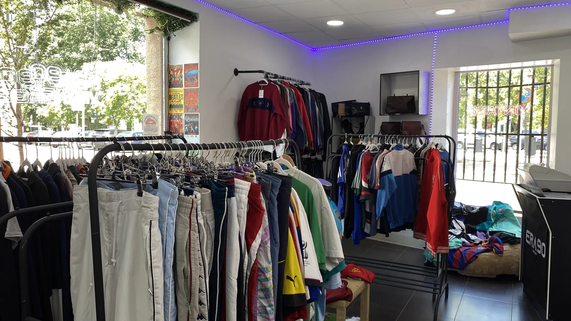Interior de la tienda ERA90 con percheros y luz natural